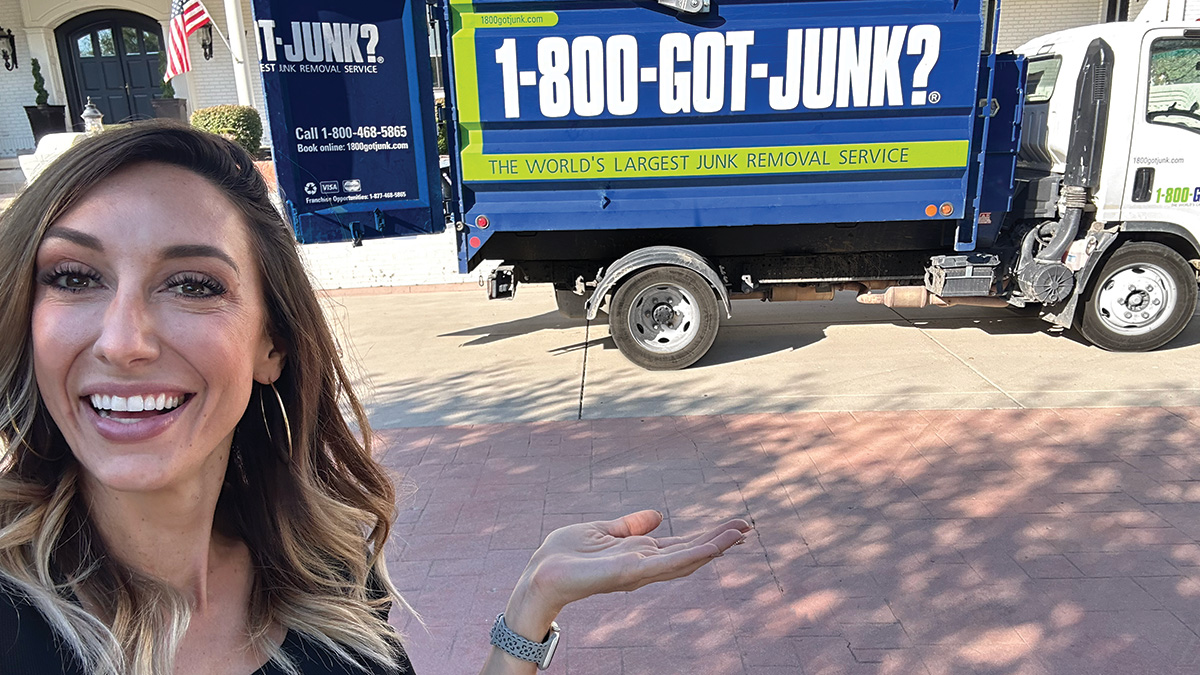 Jordan Page Top Image Jordan Page smiling while pointing at a 1-800-GOT-JUNK? truck parked outside her house