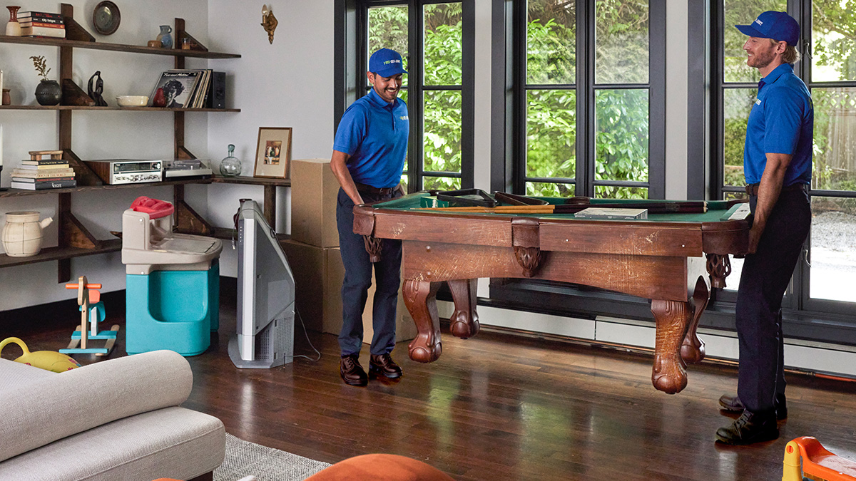 Top-Image-1200x675.jpg 1-800-GOT-JUNK? team carrying an old pool table outside of a house
