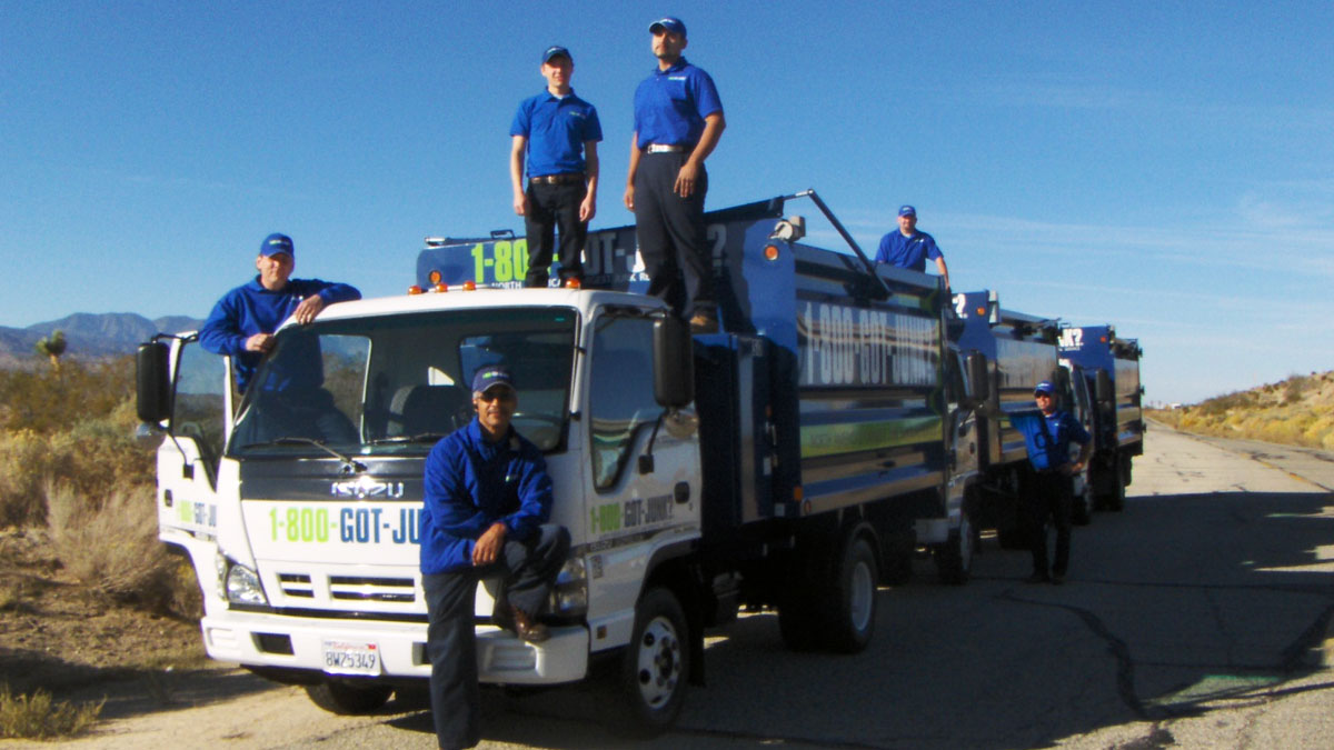1-800-GOT-JUNK? crew standing in and around 3 junk trucks 1-800-GOT-JUNK? crew standing in and around 3 junk trucks