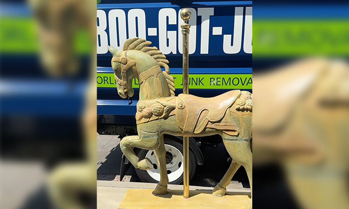 A carousel horse in front of the 1-800-GOT-JUNK? truck