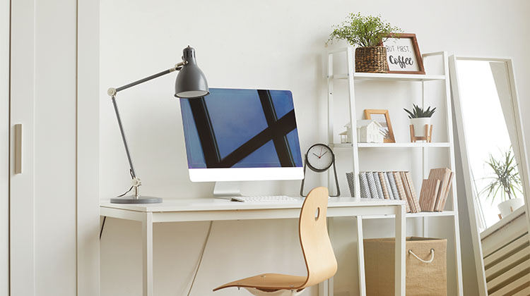 Organized home office with a computer and shelving Organized home office with a computer and shelving
