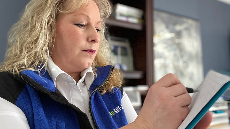 Pierrette wearing a 1-800-GOT-JUNK? vest while writing a list Pierrette wearing a 1-800-GOT-JUNK? vest while writing a list