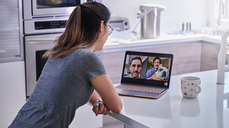 Woman video chatting with friends in her kitchen Woman video chatting with friends in her kitchen
