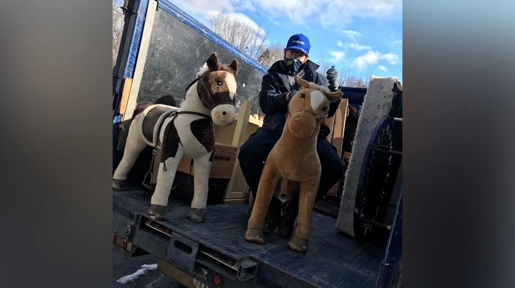 1-800-GOT-JUNK? team member with stuffed horse toys 1-800-GOT-JUNK? team member with stuffed horse toys